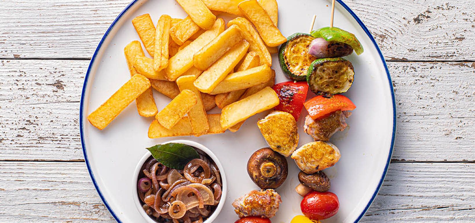 Курячі шашлички з сальсич’єю, овочами, карамелізованою цибулею та Steak Fries