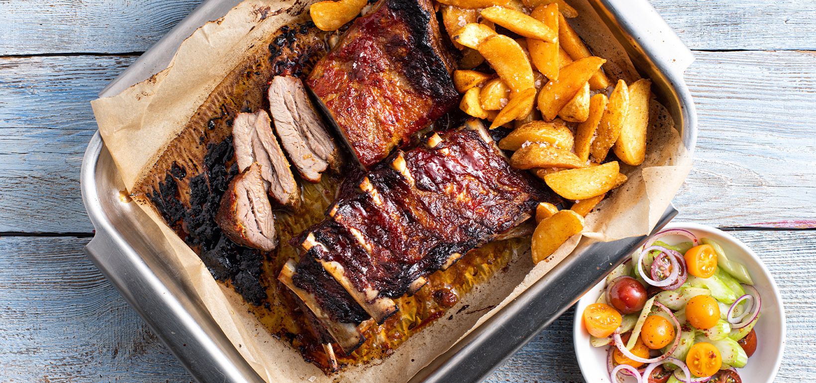 Реберця, мариновані в соусі salsa барбекю, з салатом, коріандром і кислою сметаною, подавані з пікантними шматочками картоплі Pati Parts Tex Mex